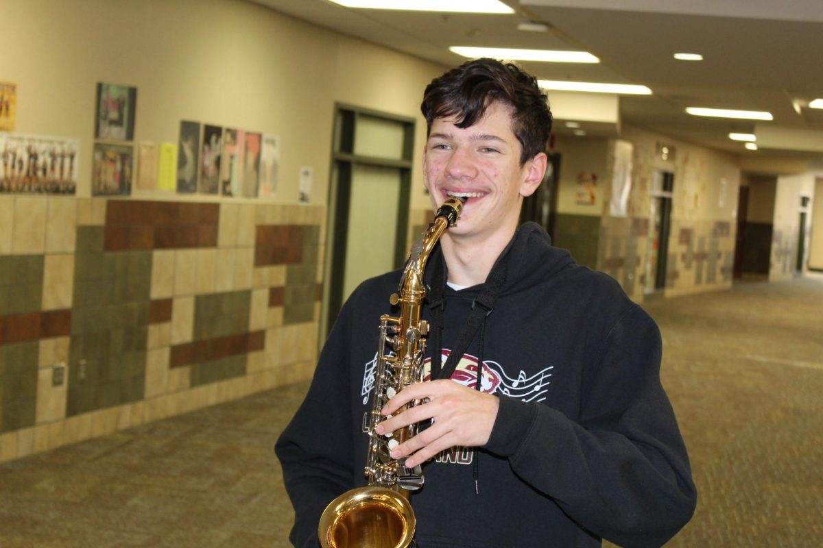 Ethan McMillan posing with his saxophone