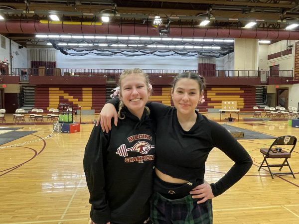 Sarah Banitt and Claire Pastotnik smiling for a picture before the Northfield weightlifting meet.
